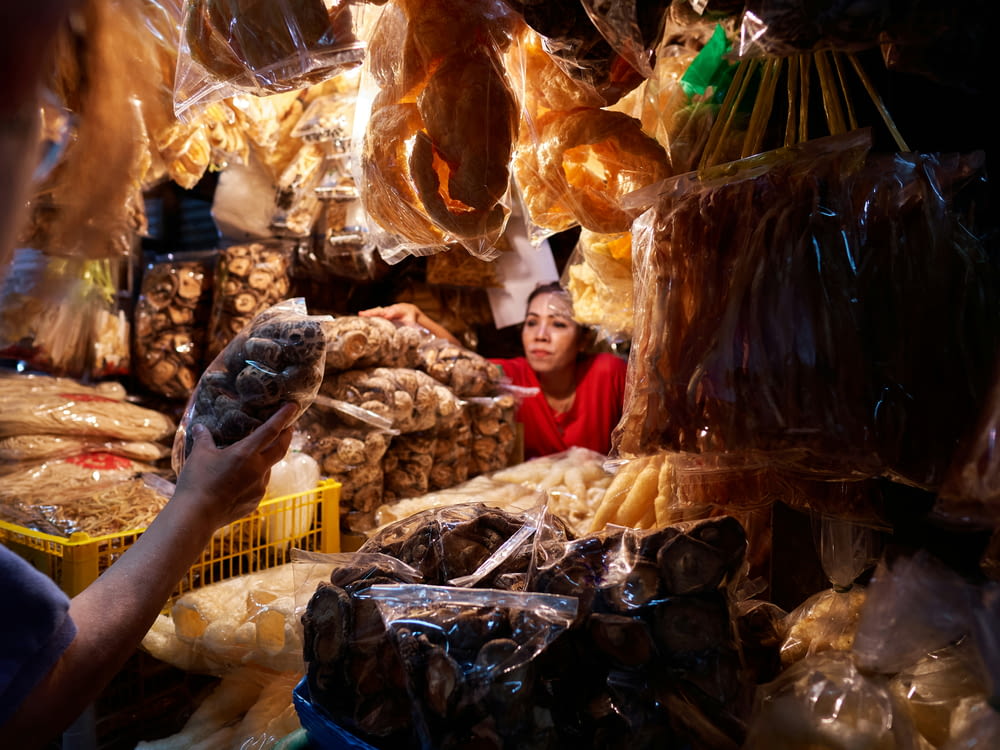 a woman standing in a store filled with lots of food