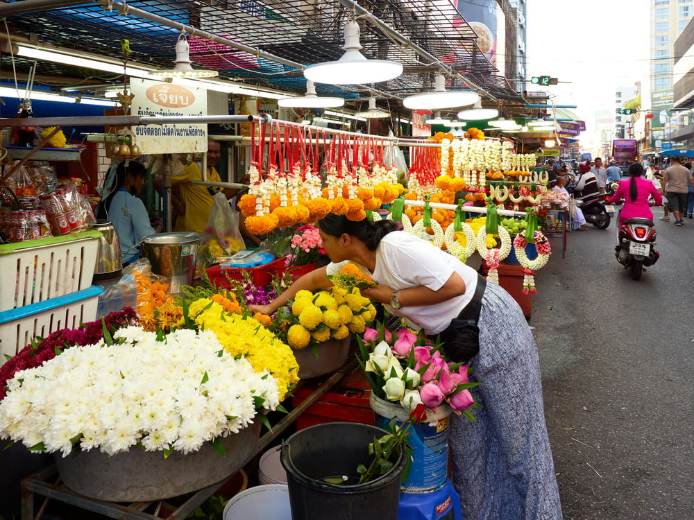 a woman standing in front of a flower stand