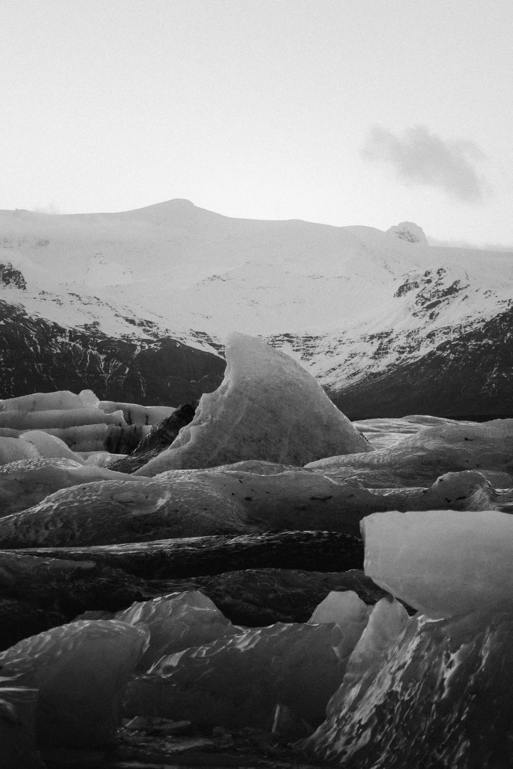 a black and white photo of mountains and ice