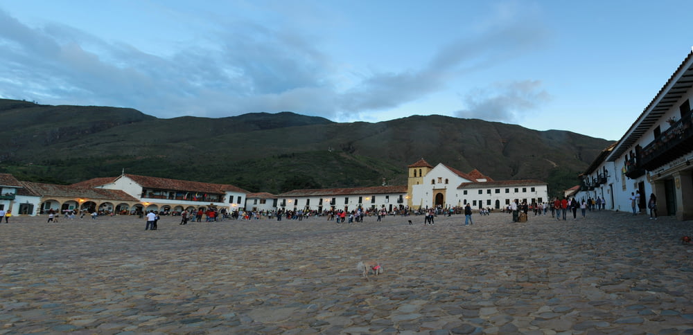 a group of people walking around a cobblestone street
