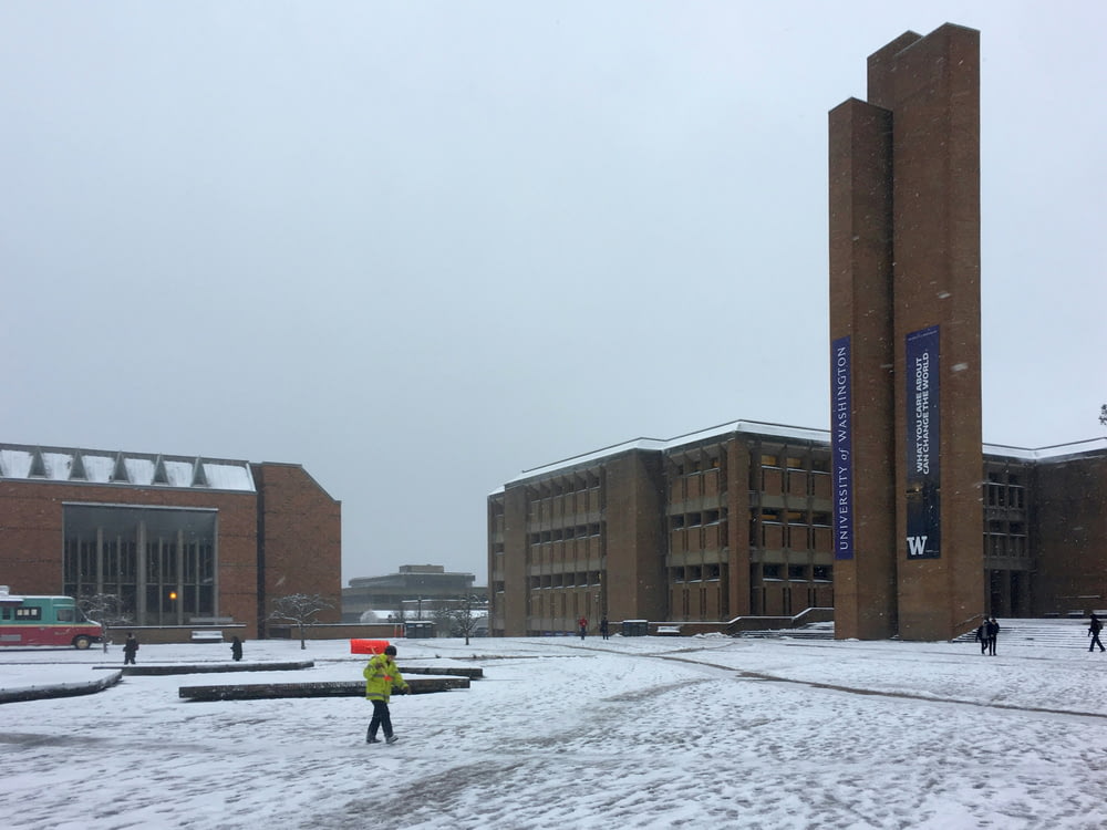 a person standing in the snow in front of a building
