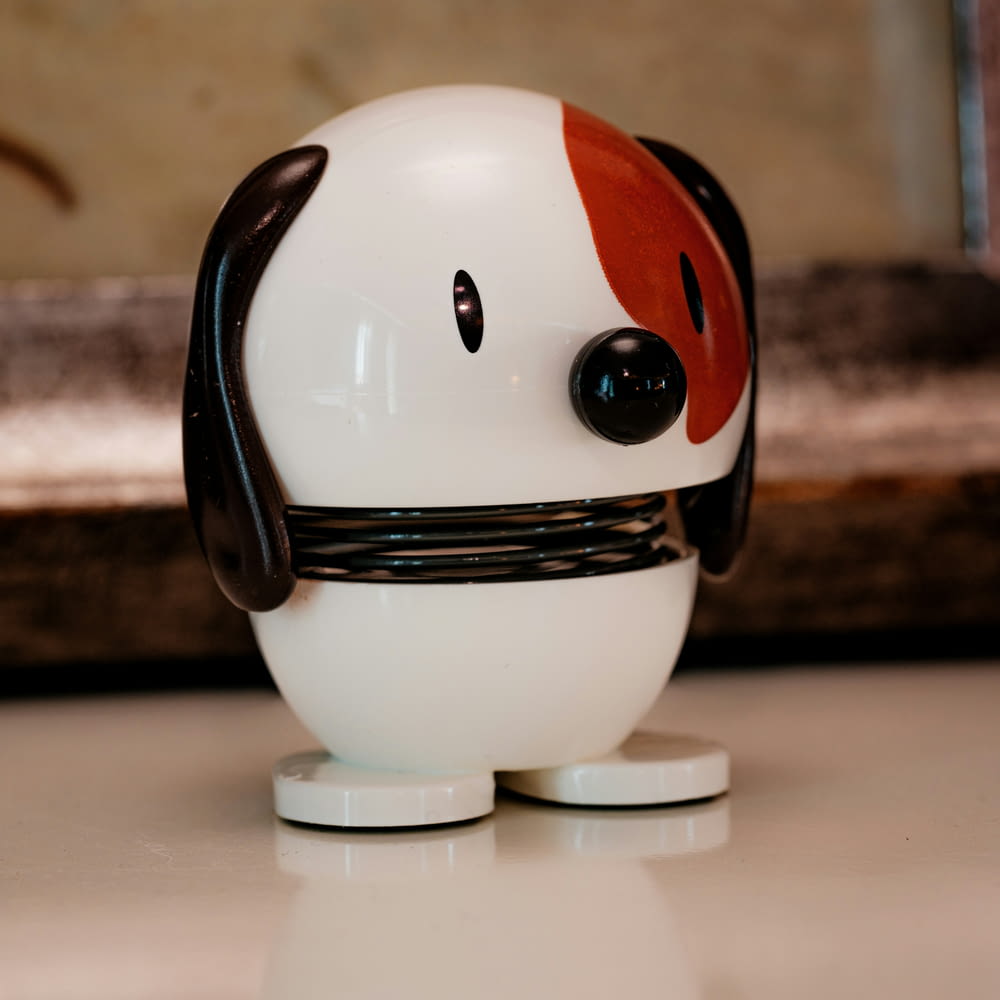 a white and red toy with a black nose