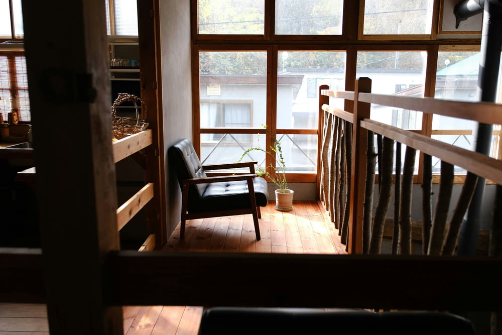 une chaise posée sur un plancher en bois à côté d’une fenêtre