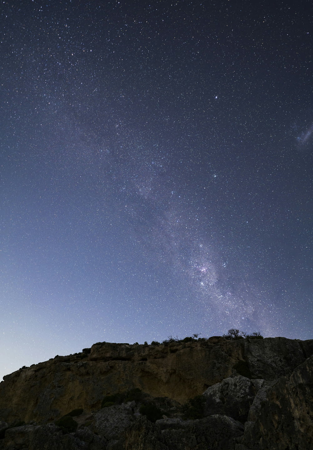 a person standing on top of a mountain under a night sky