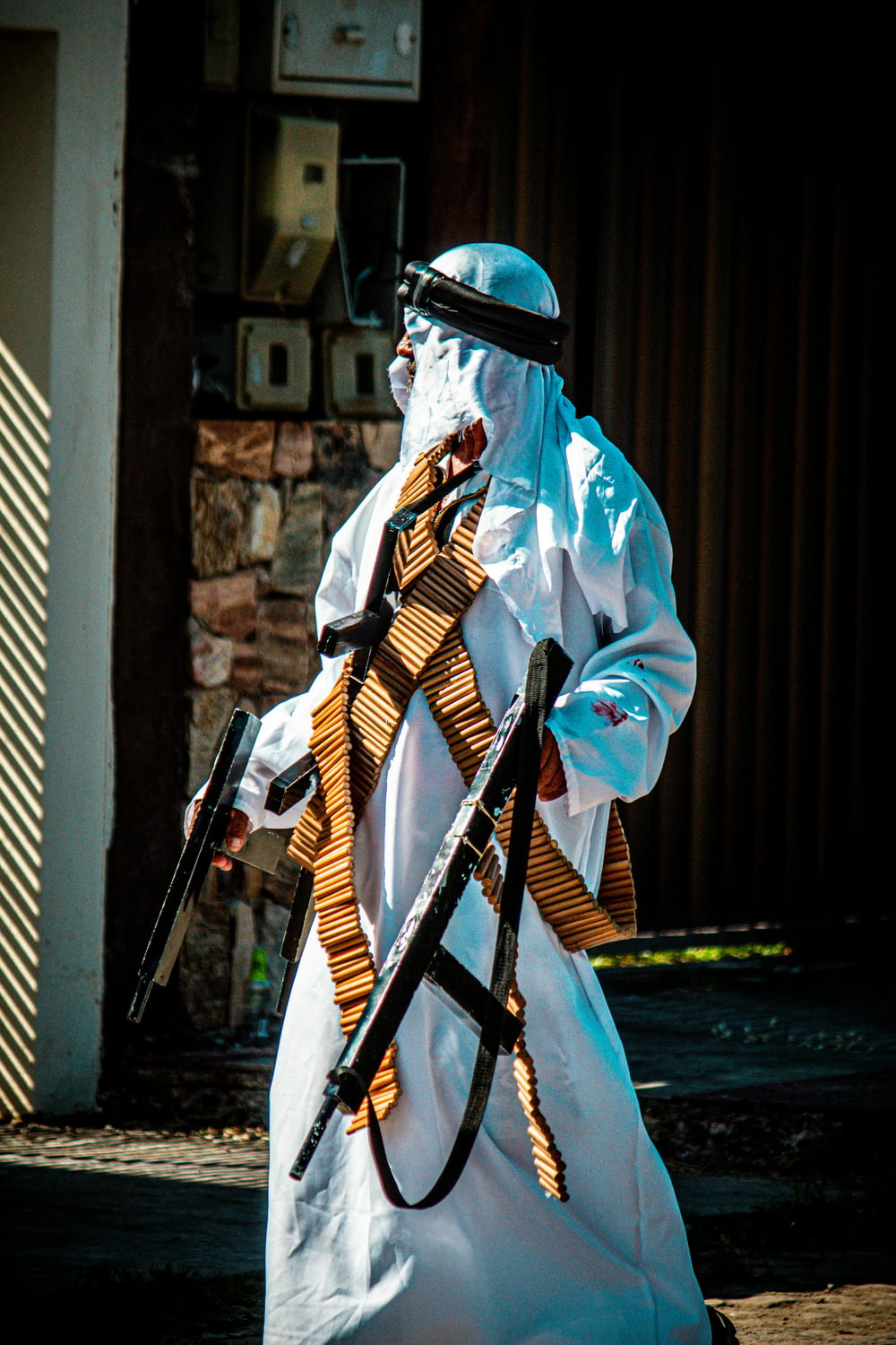 a man dressed in a white outfit and holding two guns