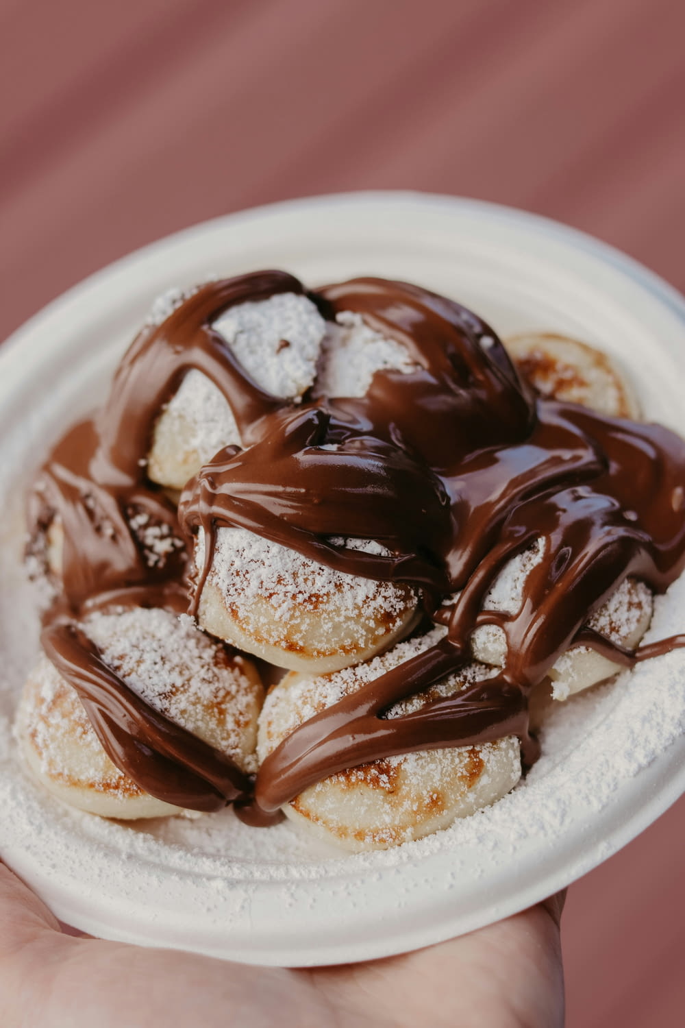 a white plate topped with chocolate covered donuts