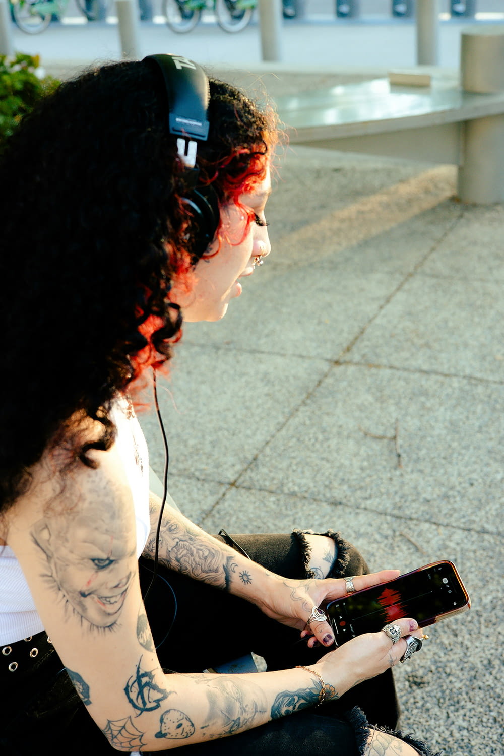 Una mujer sentada en el suelo con los auriculares puestos