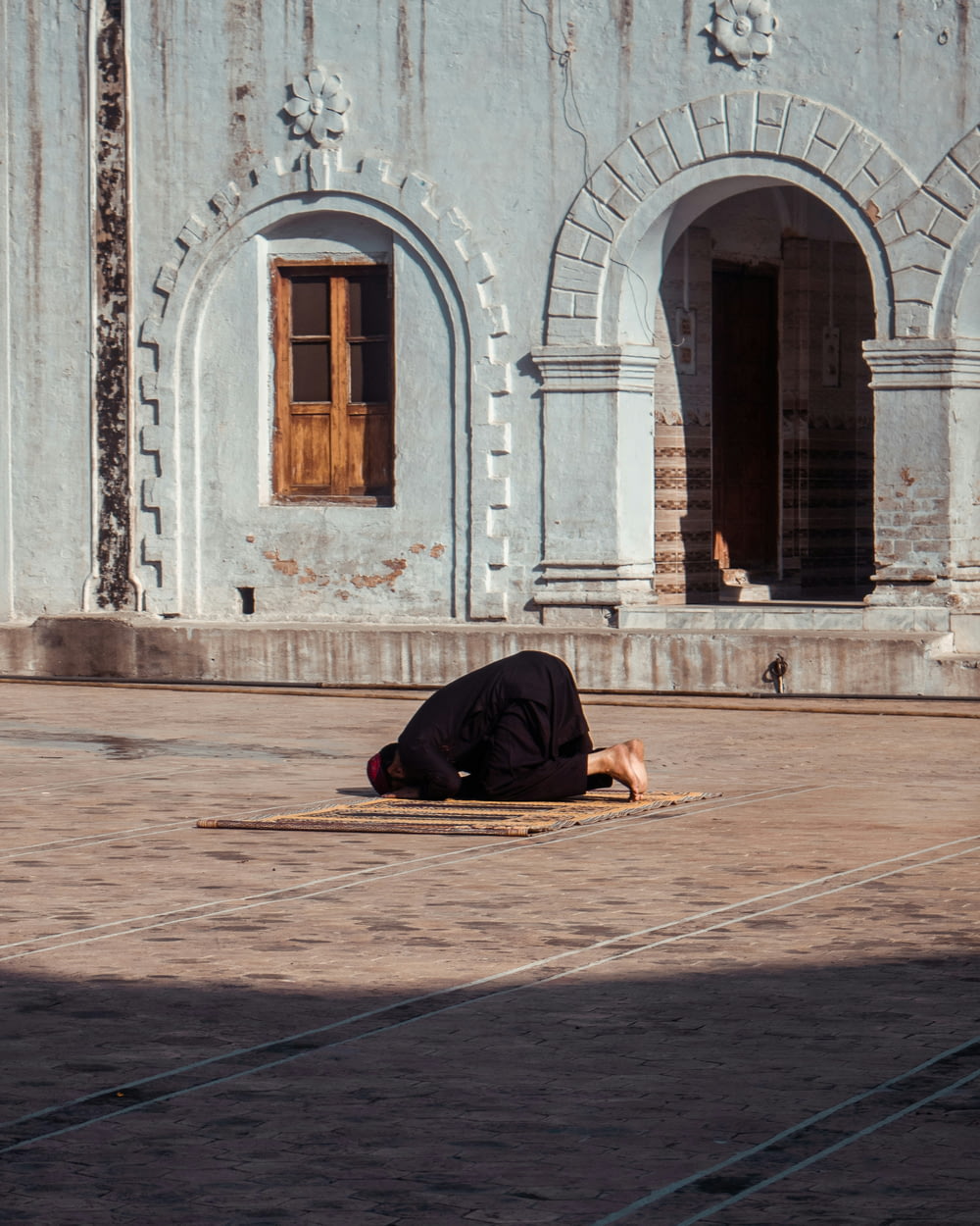 a person laying on the ground in front of a building