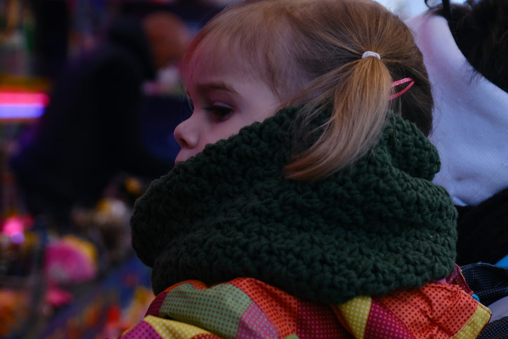 a little girl wearing a scarf around her neck