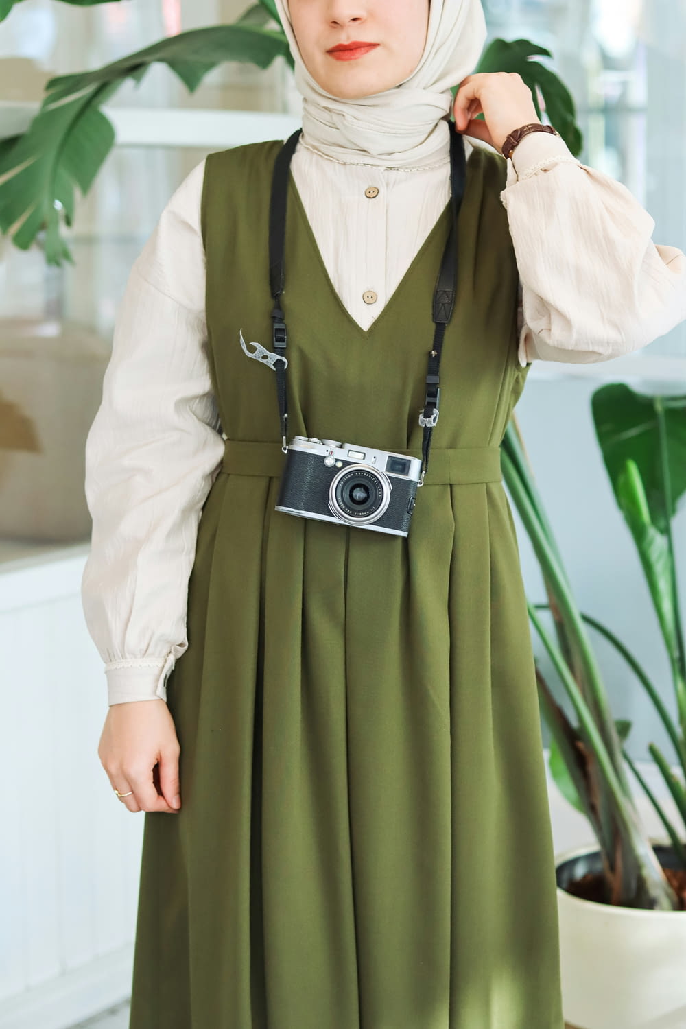 a woman in a green dress with a camera