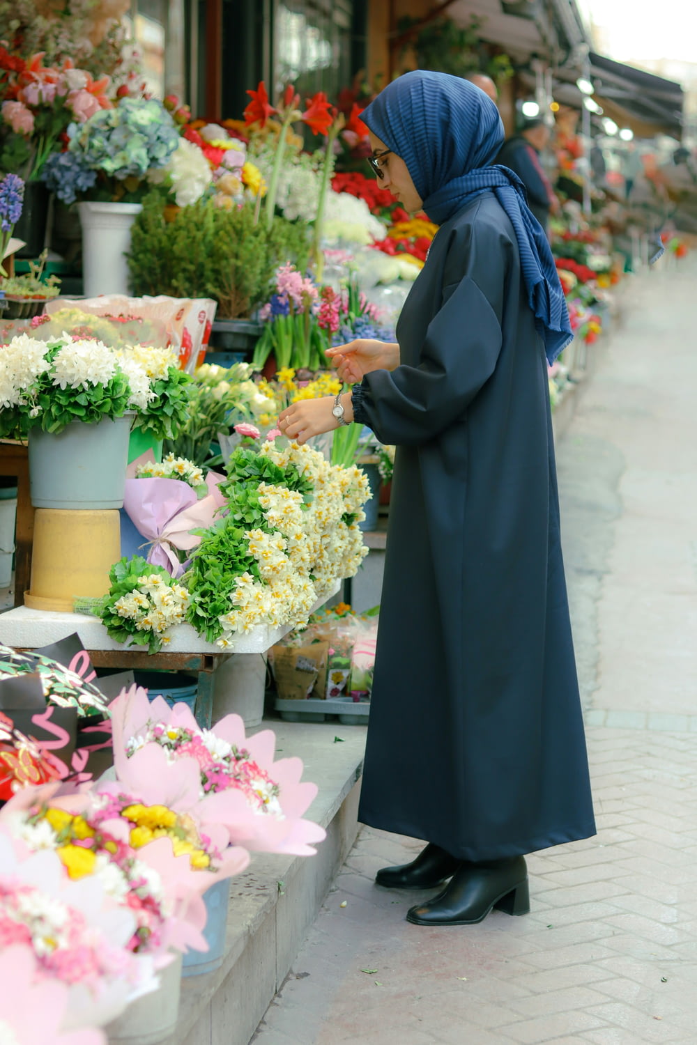 a woman standing in front of a flower shop
