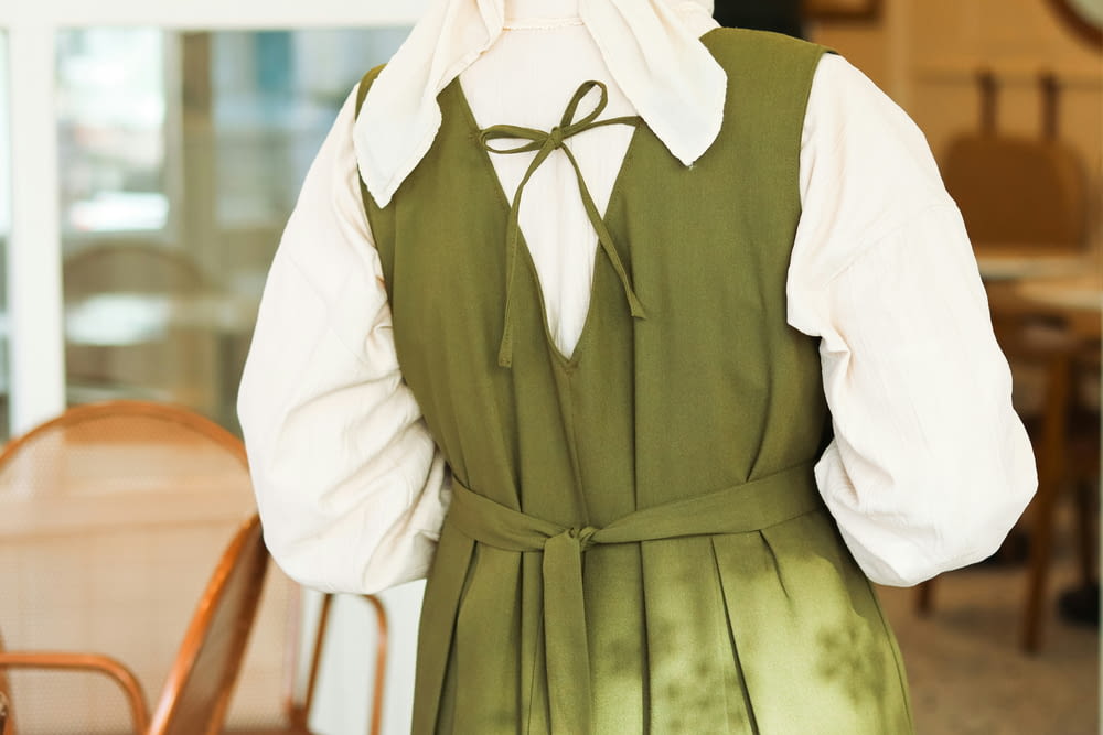 a person wearing a green dress and a white shirt