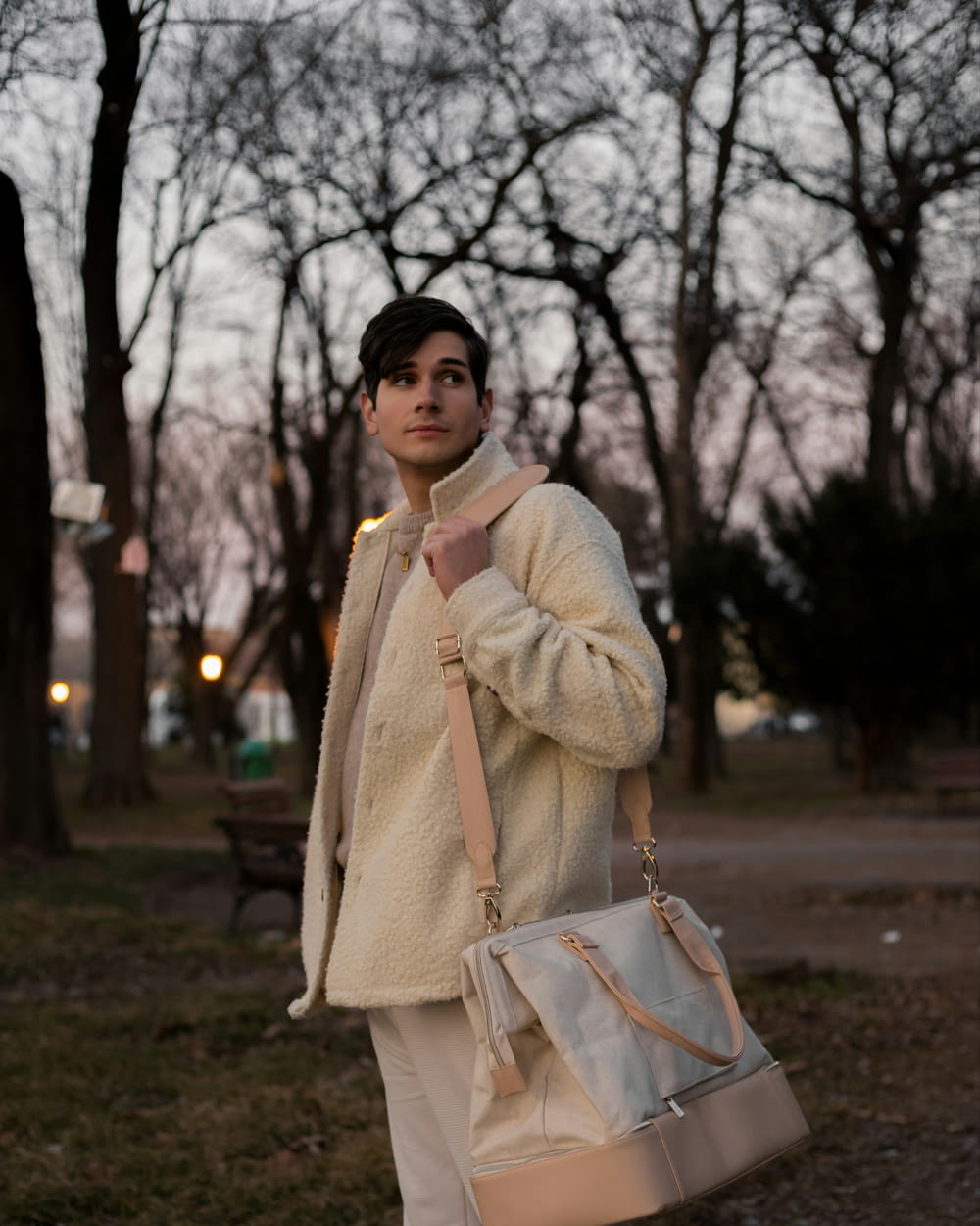 a man in a white jacket is holding a purse