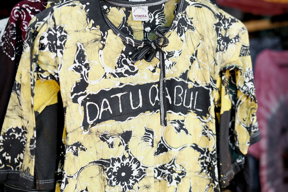 a yellow shirt with black and white designs on it