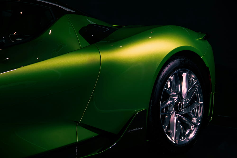 Une voiture de sport verte garée dans une pièce sombre