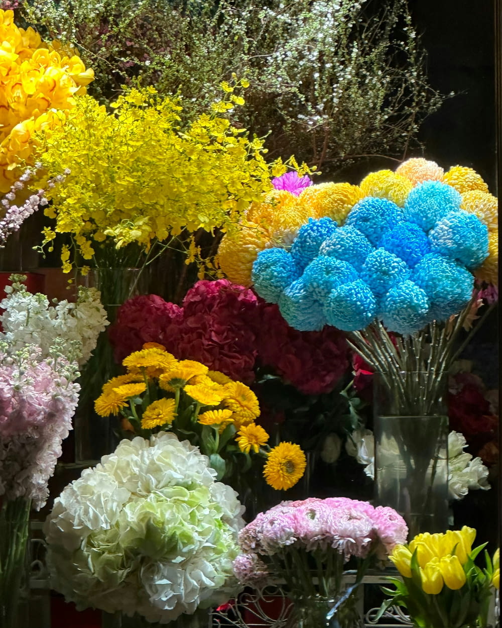 a bunch of different colored flowers in vases