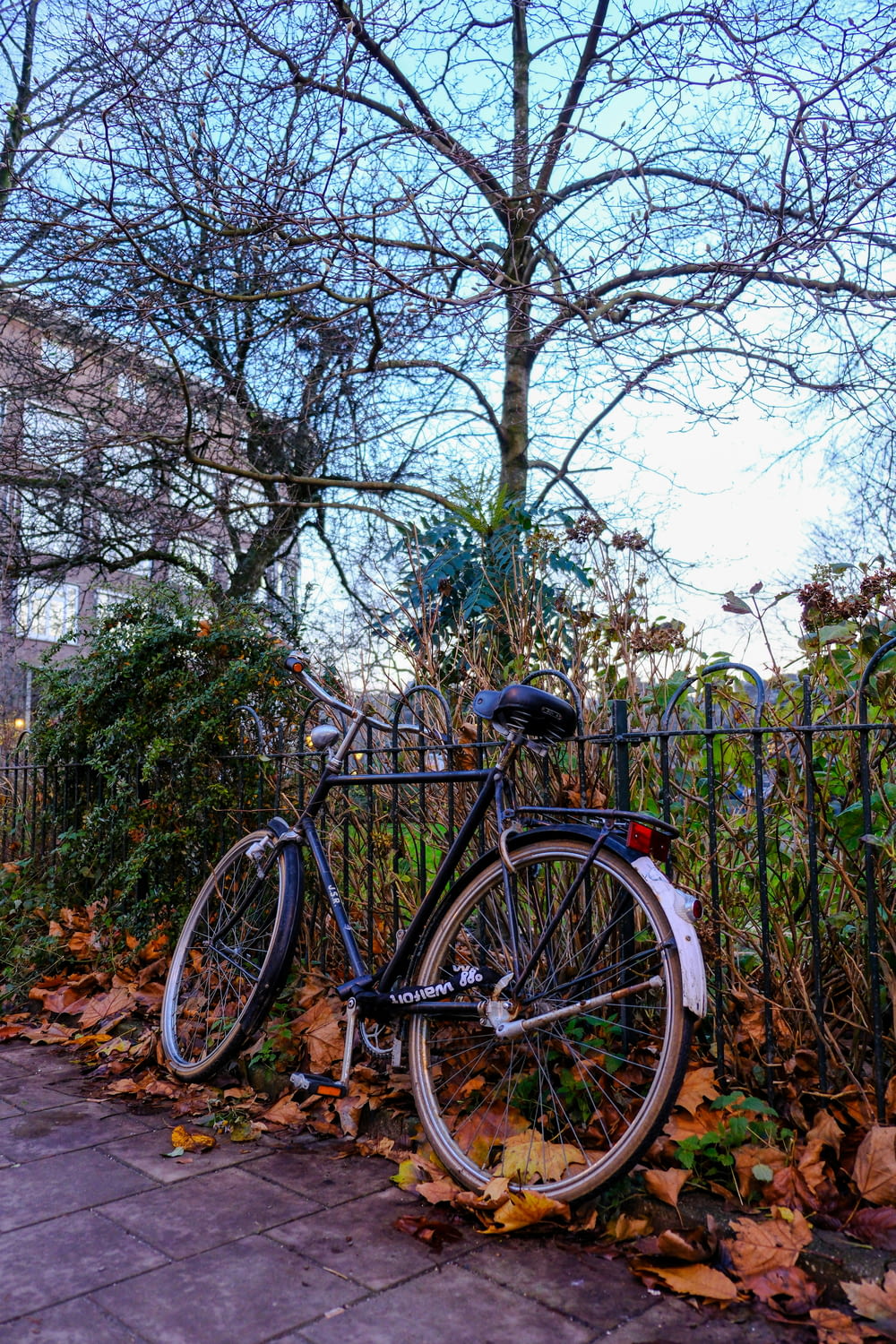 a bicycle is parked next to a fence