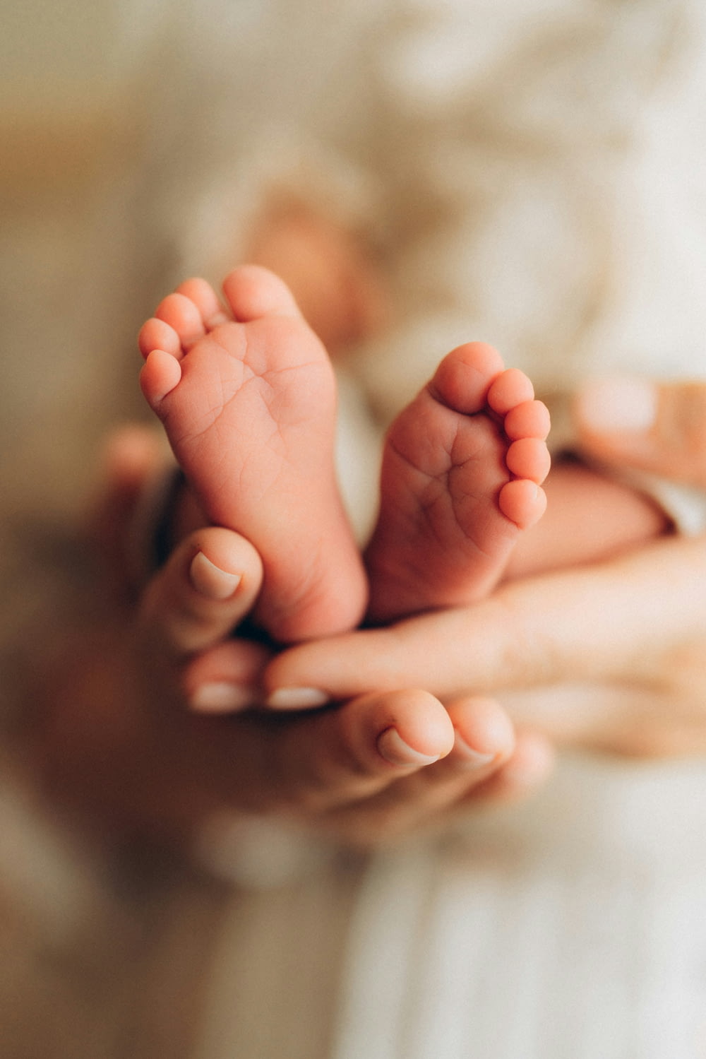 a person holding a baby's feet in their hands