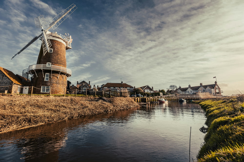 a windmill sitting on the side of a river
