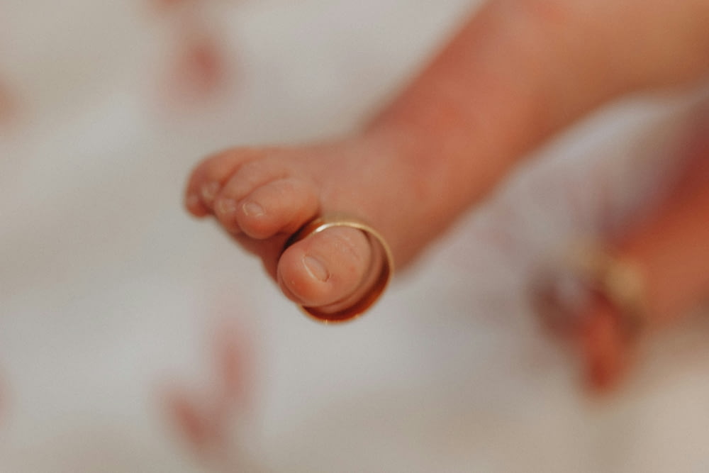 a close up of a baby's hand with a ring on it