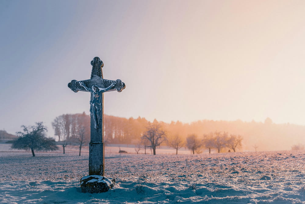 a cross in the middle of a snowy field