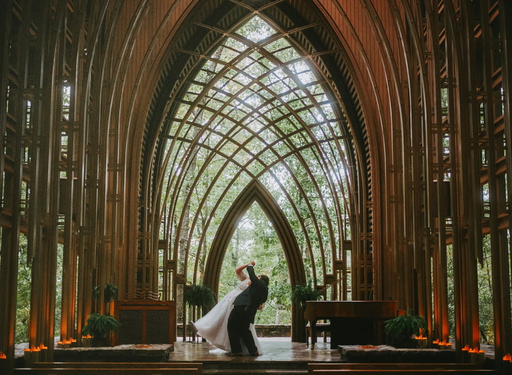 a bride and groom standing in front of a cathedral
