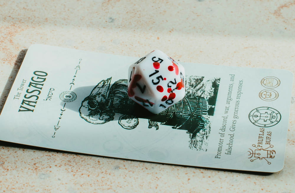 a white and red dice sitting on top of a piece of paper