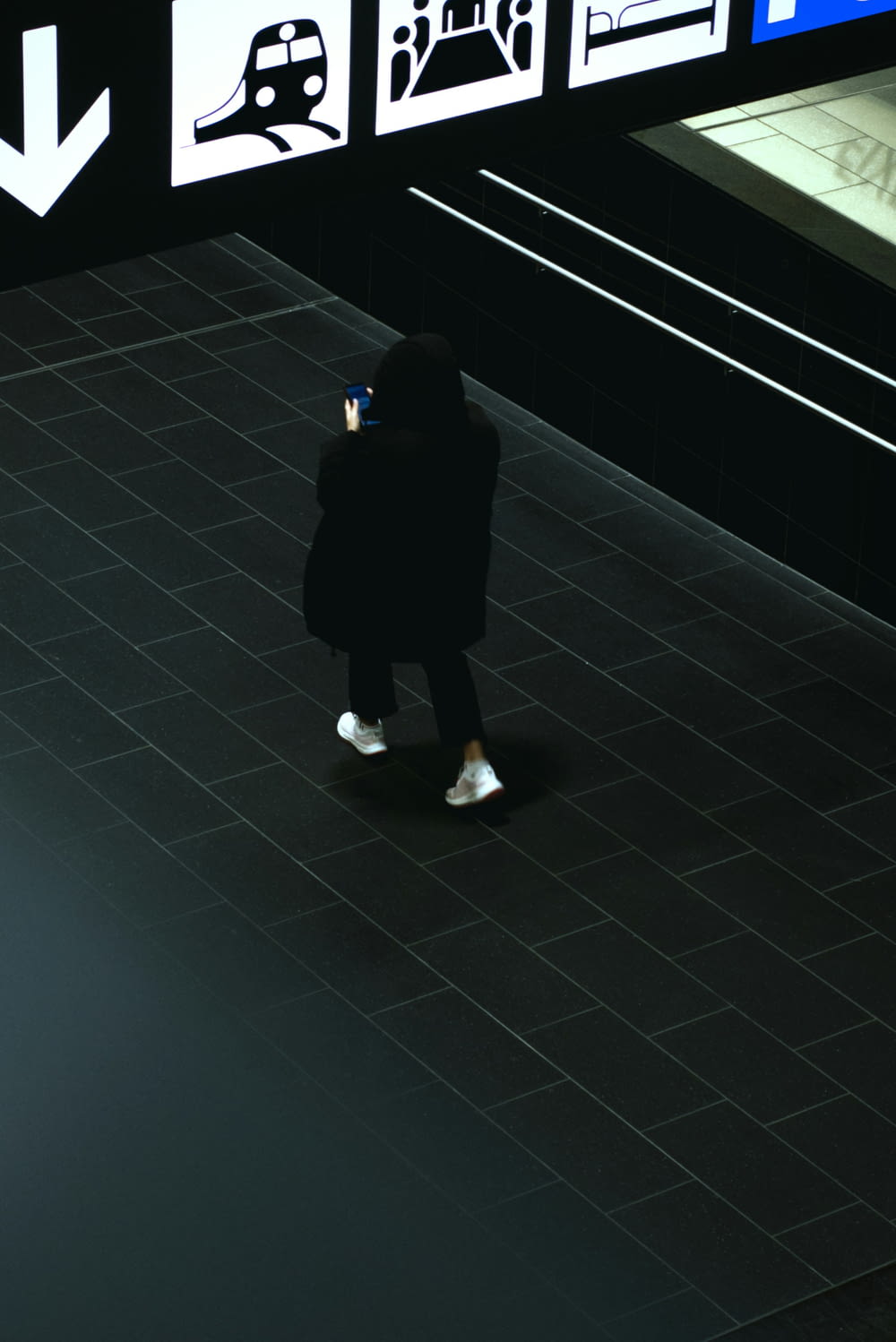 uma pessoa de casaco preto e sapatos brancos