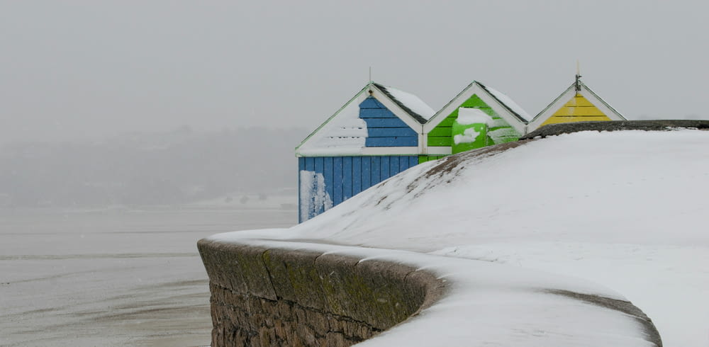 a row of colorful beach huts covered in snow