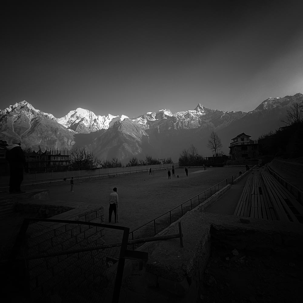 a black and white photo of a field with mountains in the background