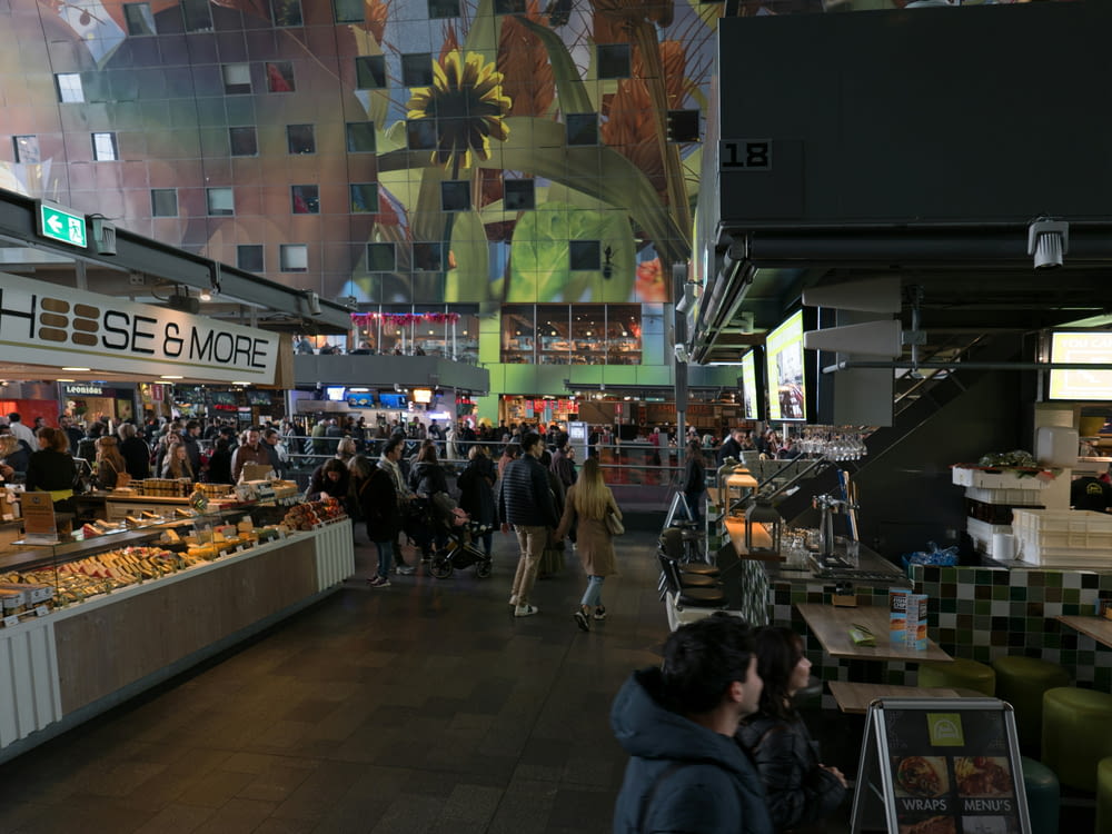 a large group of people walking around a market