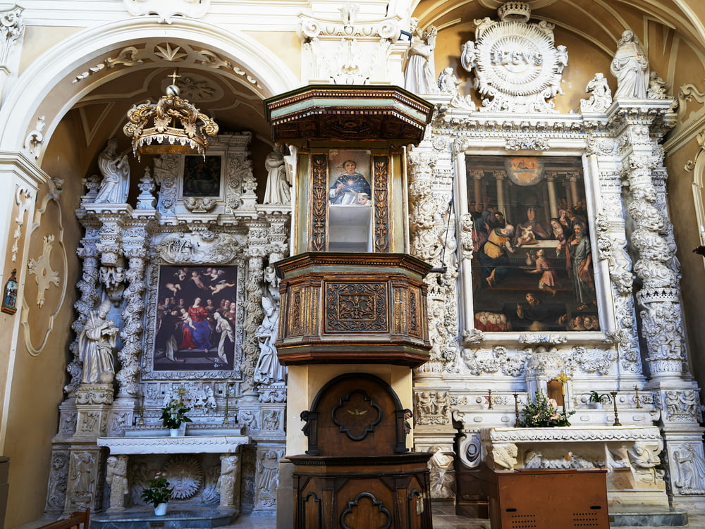 a church with a clock and paintings on the wall