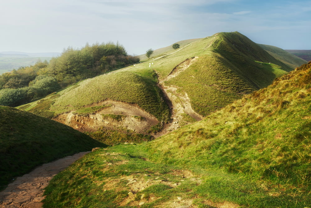 un camino de tierra que sube por una colina cubierta de hierba