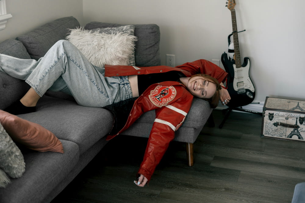 a woman laying on a couch in a living room