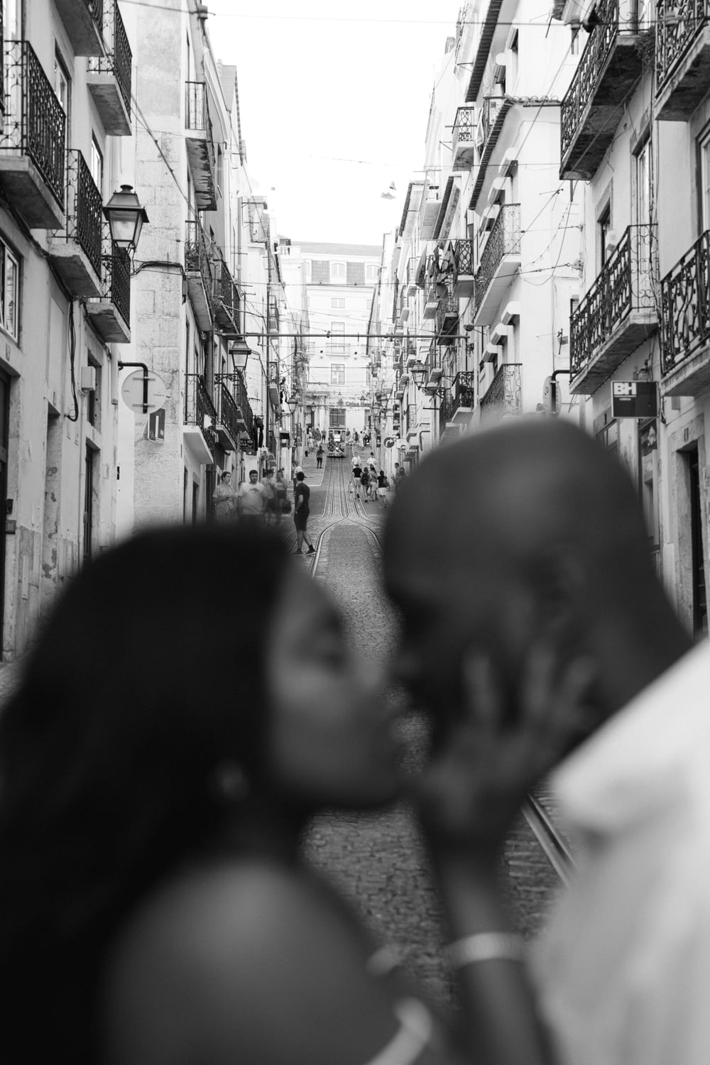 a black and white photo of a man kissing a woman