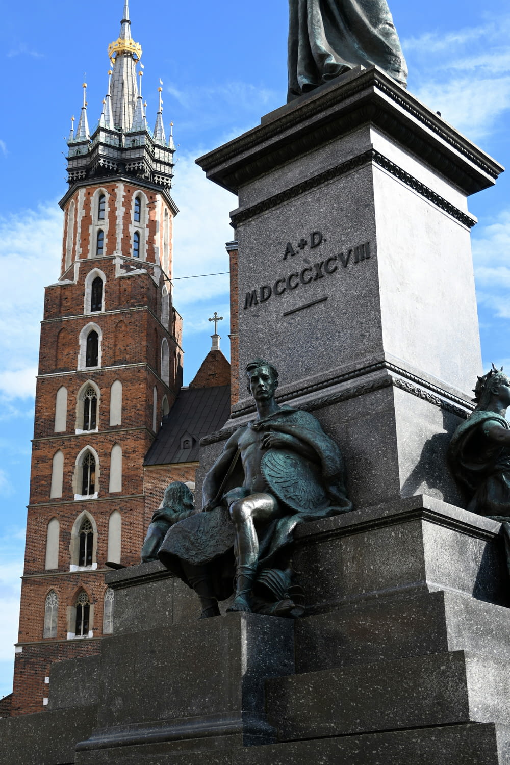a statue in front of a tall building with a clock tower