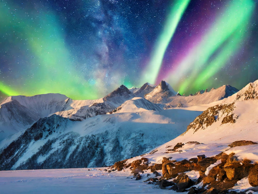 the aurora bore over a snowy mountain range