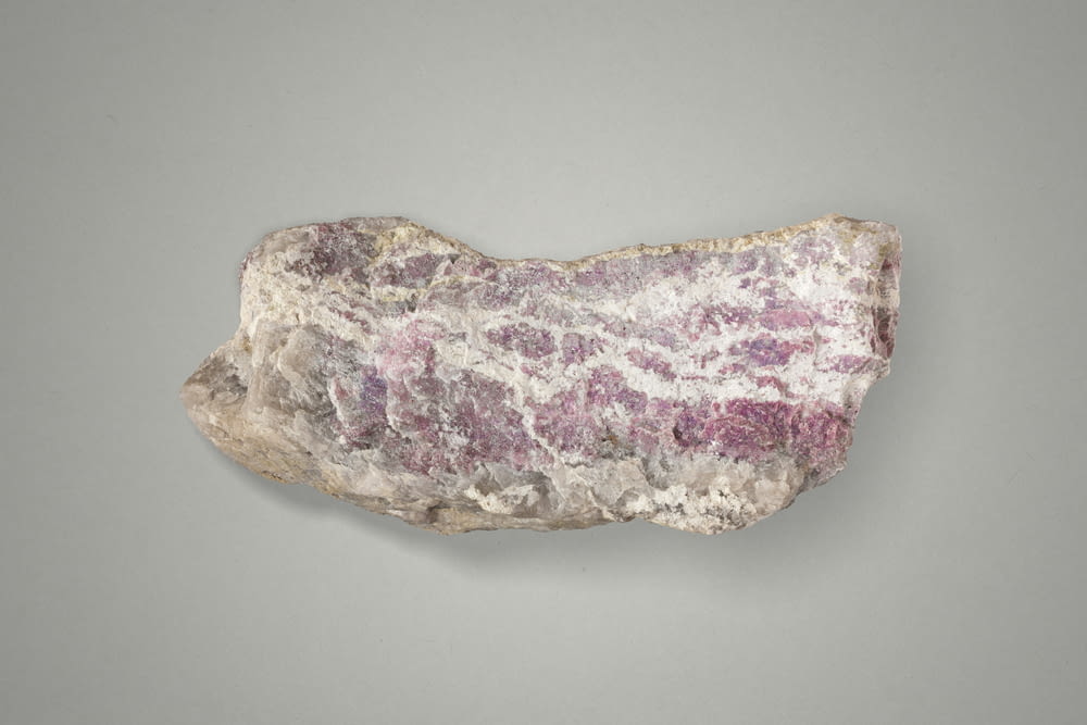 a rock with a pink and white substance on it