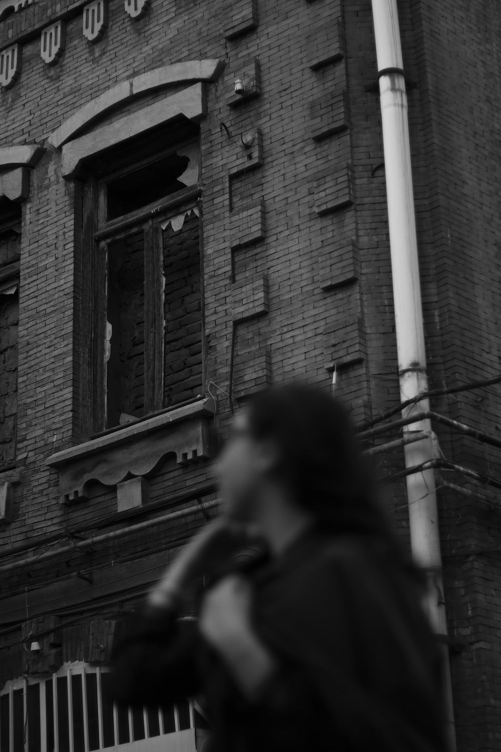 a black and white photo of a person standing in front of a building