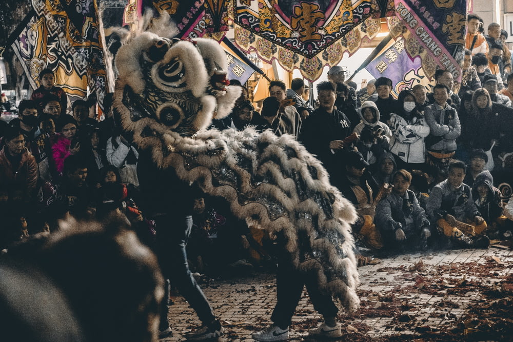 a group of people standing around a lion dance