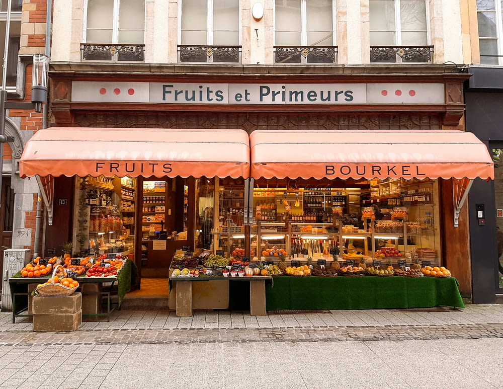 a fruit shop with orange awnings on the front of it