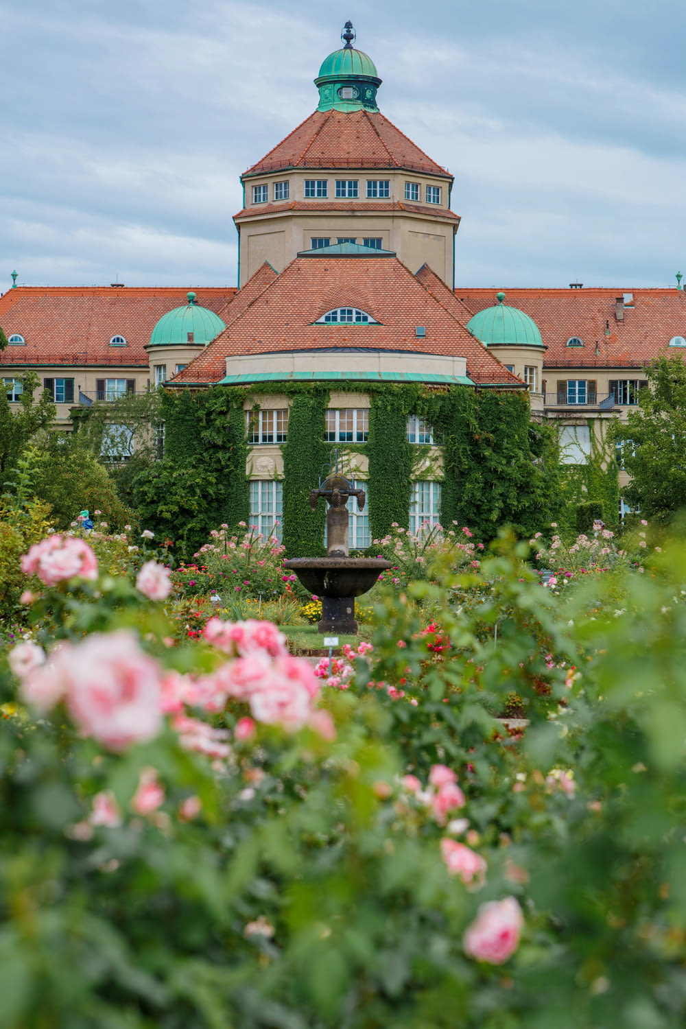 a building with a fountain surrounded by flowers