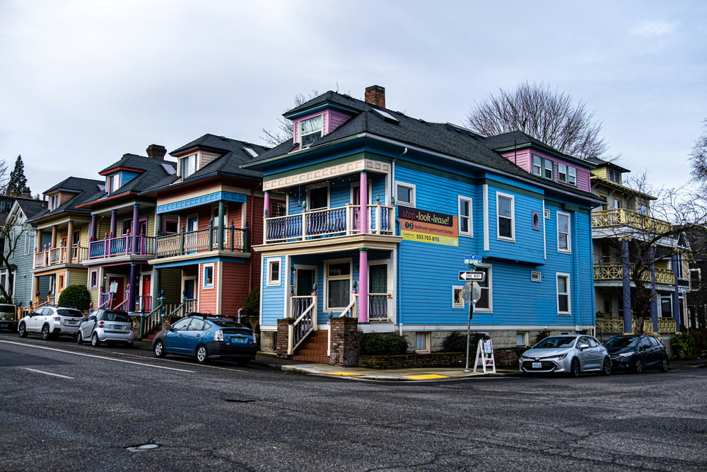 a row of multi - colored houses on a street corner