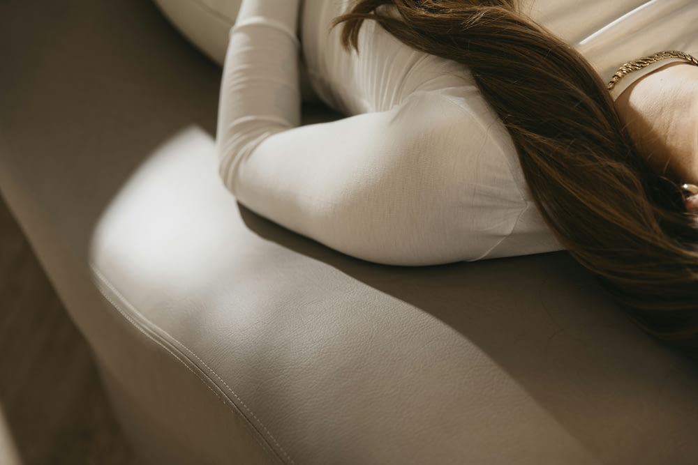 a woman with long hair laying on a couch