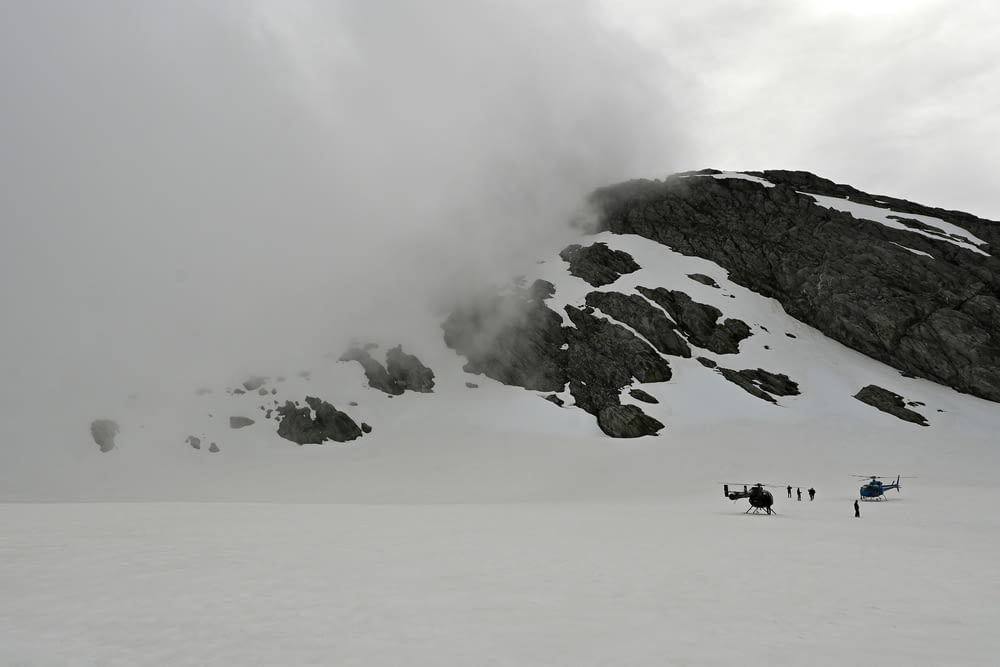 a group of people standing on top of a snow covered slope