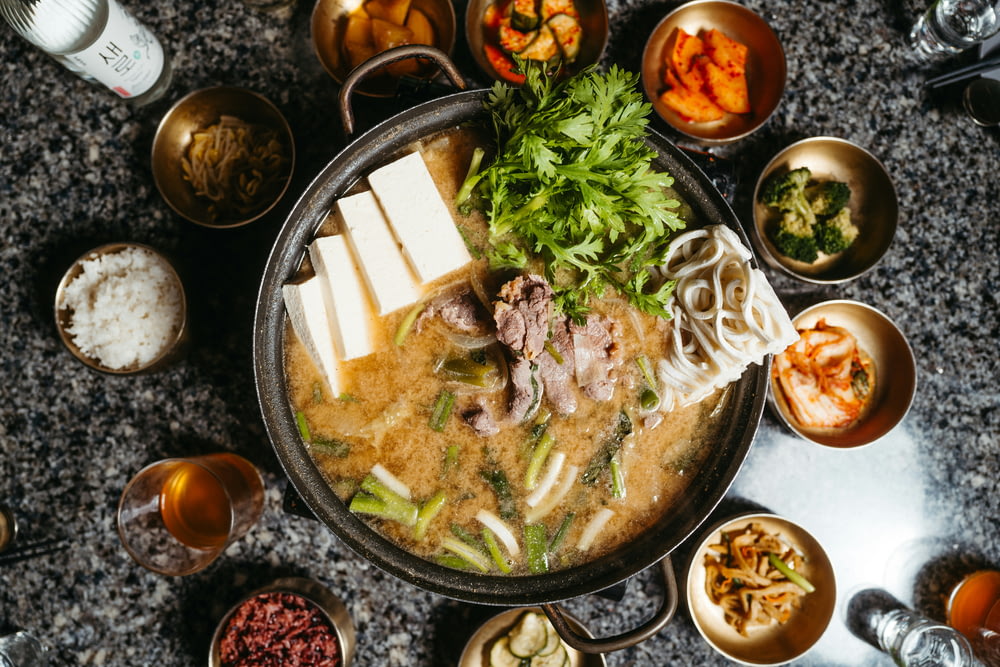 a bowl of soup with chopsticks on a table