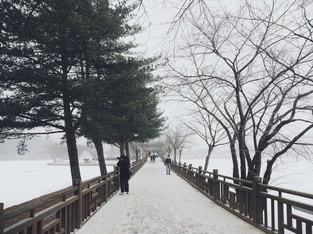 people walking on a bridge in the snow