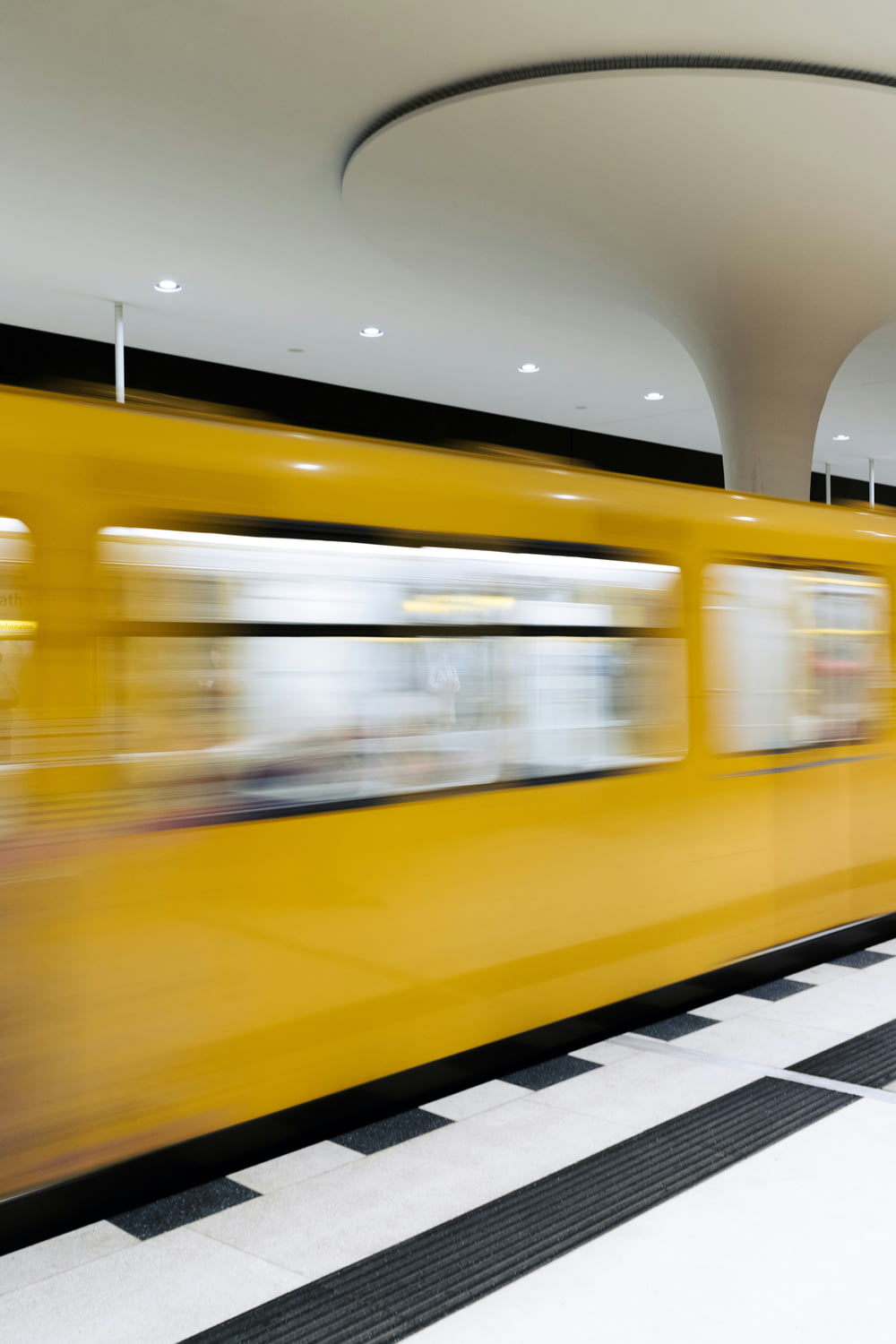 a yellow train traveling through a train station