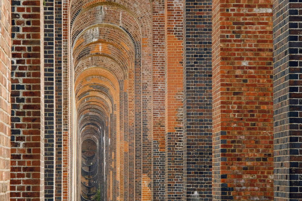 a group of people walking through a brick tunnel