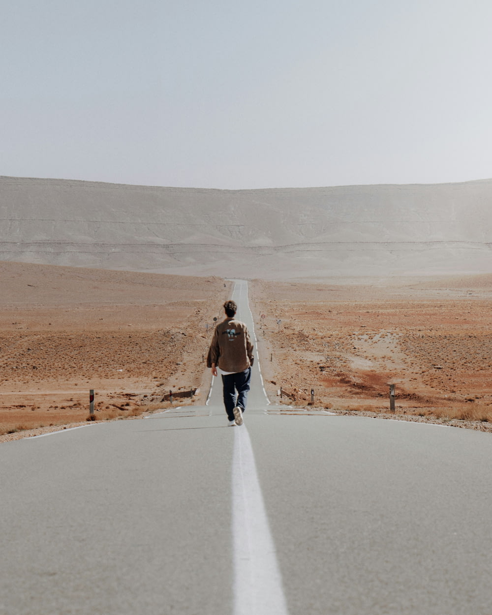 a man walking down the middle of a road